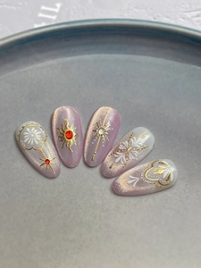 Detail of lavender cat-eye nail art with 3D sun and star patterns on ceramic display