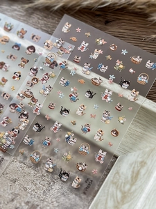 Detail of 3D embossed nail stickers featuring cute cartoon cats and faux pearl accents