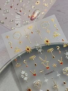 Detail of vintage bohemian 3D metallic sun and moon nail art stickers with gems