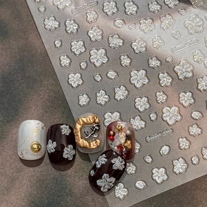 Embossed white floral nail art stickers with 3D flower designs and elegant gold accents