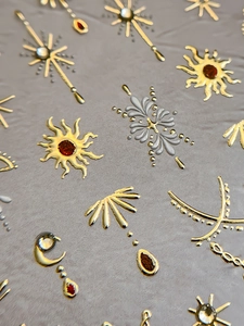 Detailed macro view of 3D metallic bohemian nail stickers with gold and silver sun patterns
