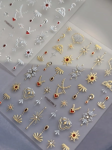 Detail view of Bohemian nail art stickers with gold sun moon motifs and red hearts