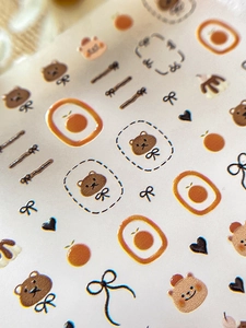 Vue macro de stickers d'ongles 3D en relief avec motifs ours et nœuds mignons