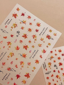 Detail showing autumn maple leaf nail decals with elegant Chinese calligraphy design
