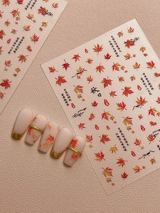 Detail of autumn maple leaf nail art stickers with embossed patterns and Chinese elements