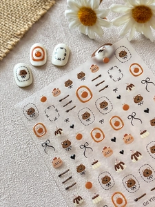 Vue détaillée d'autocollants pour ongles oursons et oranges avec pointes de vernis blanc