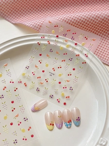 Dettaglio di adesivi per unghie mini frutta con motivi colorati di ciliegia e limone