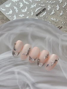 Detailed view of pink press-on nails with silver leaf embossing and delicate rhinestones