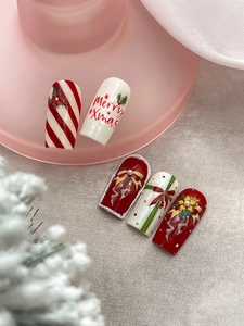 Macro di nail art natalizia 3D con fiocchi rossi, perle e scritte Merry Xmas dipinte a mano