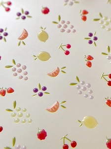Dettaglio della texture 3D di adesivi per unghie con motivi di frutta colorata e fresca