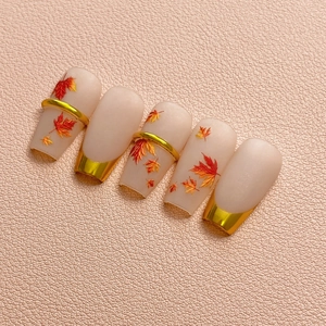 Autumn matte press-on nails with realistic maple leaf patterns and gold metallic accents