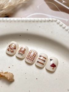 Detail of cute cartoon dog and bear nail art stickers on cream white press-on nails
