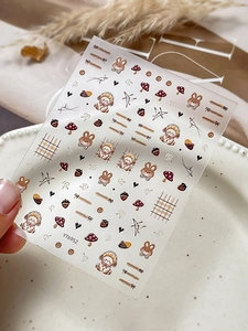 Detailed sheet of cute rabbit nail stickers with teddy bear, stars, and red mushrooms