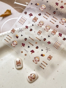 Detail of cute bear and rabbit nail stickers with mushroom patterns in warm tones