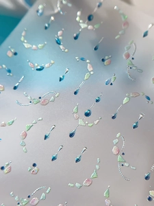 Macro shot of silver laser shell gemstones and 3D nail art stickers with chain details