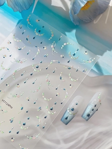 Detail of silver laser shell nail stickers with teardrop gems and French style decals