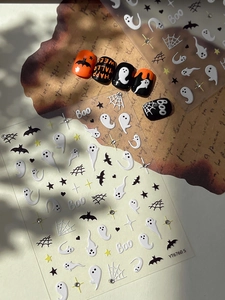 Detailed Halloween nail art set featuring ghost and bat patterns on vintage paper backdrop