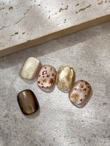 Detailed view of autumn maple leaf nail stickers with golden cat-eye effect and plaid designs