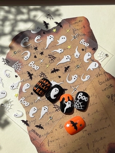 Macro detail of Halloween nail art stickers with ghost, bat and spider web patterns