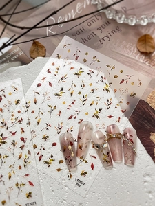 Detailed view of autumn leaf nail stickers and application on manicured nails