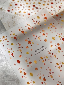 Exquisite maple leaf nail art stickers with autumn-themed colors and textured paper