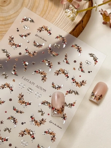 Macro detail of 3D autumn leaf nail art stickers with wreaths and champagne gold accents