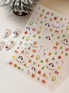 Macro shot of 3D embossed Christmas nail art stickers featuring Santa and reindeer designs
