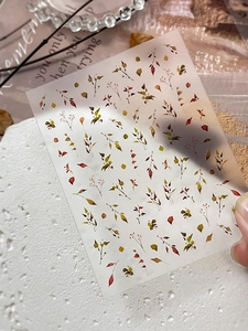Macro detail of translucent autumn leaf nail art stickers with red and orange foliage