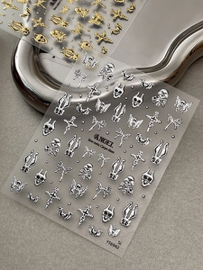Makroaufnahme von gotischen 3D-Nagelstickern in Gold und Silber mit Totenköpfen