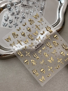 Makroaufnahme von 3D-Gothic-Nagelstickern mit goldenen und silbernen Metallrelief-Mustern