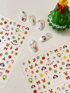 Detail of Christmas nail art stickers featuring cute cartoon Santa, reindeer and snowflakes
