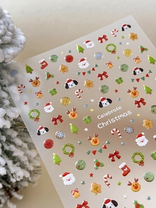 Detail of 3D Christmas nail stickers with Santa, reindeer and tree on snowy background