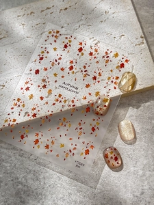 Macro detail of autumn maple leaf nail stickers on beige nails with YT7069 design sheet