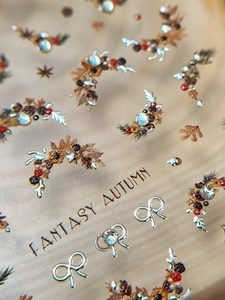 Detail of 3D embossed nail stickers featuring autumn maple leaves and silver snowflake designs