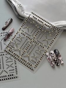 Close-up of gothic nail stickers with gold and silver metallic chain and cross patterns
