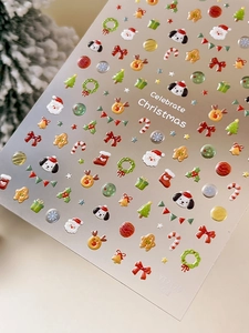 Close-up of 3D embossed Christmas nail stickers featuring Santa and reindeer designs