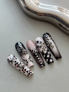 Detail of gothic punk press-on nails with silver heart and cross metal charms