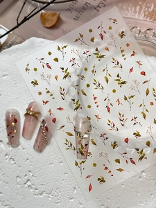 Detailed view of autumn leaf nail art stickers with deep red and olive green patterns
