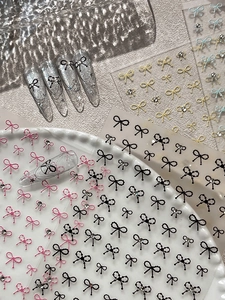 Detailed view of colorful 3D bow nail art stickers with crystal rhinestones on long nails