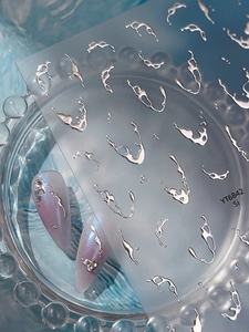Detailed macro view of silver 3D liquid metal nail stickers showing glossy 3D mirror effects
