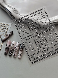 Detail of punk style nail art stickers with silver chains and metallic stud patterns