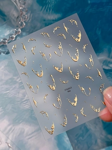 Macro detail of 3D liquid metal gold nail stickers featuring irregular fluid patterns