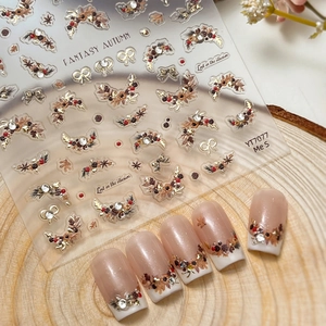 3D autumn nail art stickers with brown leaves, bows, and crystals on wood background