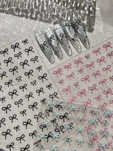 Macro detail of embossed bow-knot nail art stickers showing high-end 3D texture and glitter
