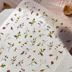 Minimalist autumn leaf nail stickers with berry patterns on white stone background