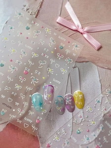 Detailed view of 3D embossed nail stickers featuring bow and star designs on colorful nails