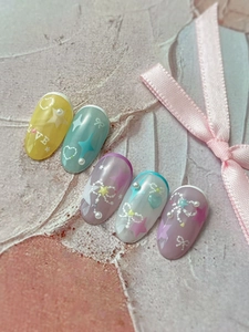 Detail of macaron star bow nail press-ons with 3D pearls and hearts on pink background
