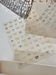 Detailed view of YT6600 bow nail stickers with yellow gems on transparent backing