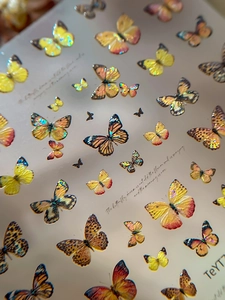 Macro view of 3D embossed butterfly nail art stickers with laser holographic finish