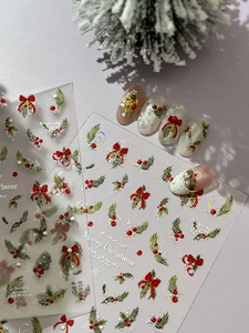 Detail of Christmas nail stickers with red bows, green pine branches, and laser glitter